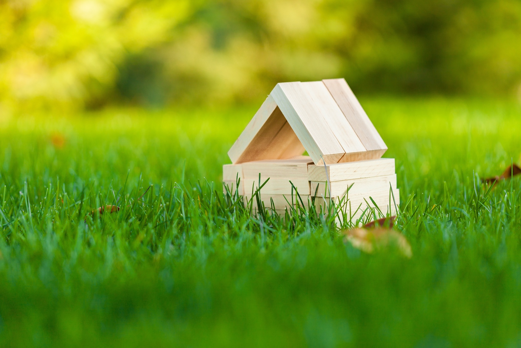 Small House Made of Wood Blocks on Grass